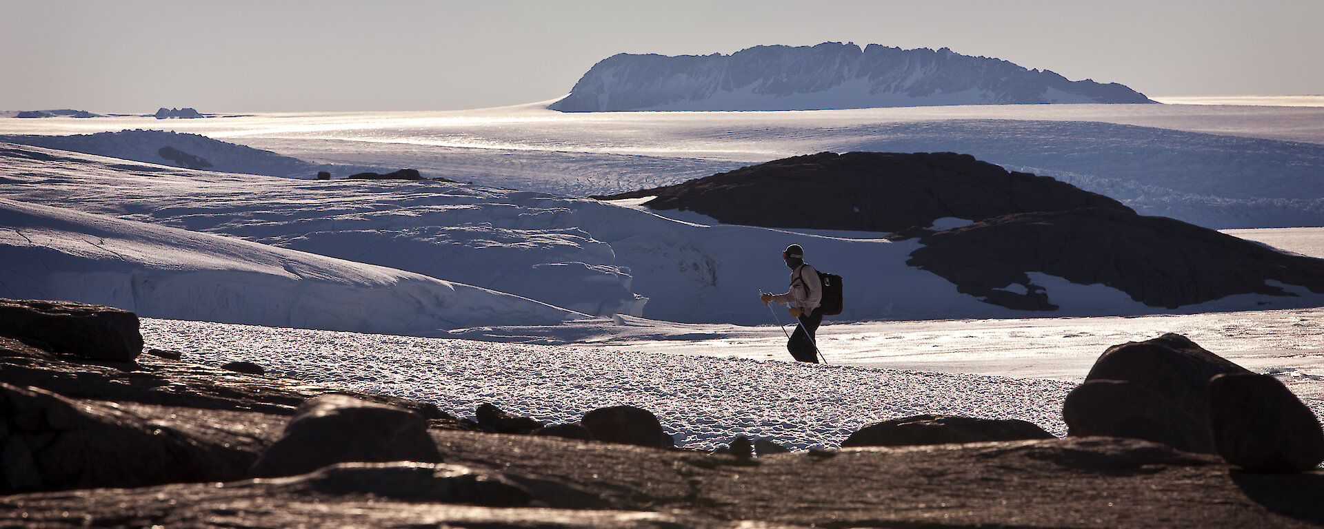 Expeditioner hiking through snow-covered landscape.